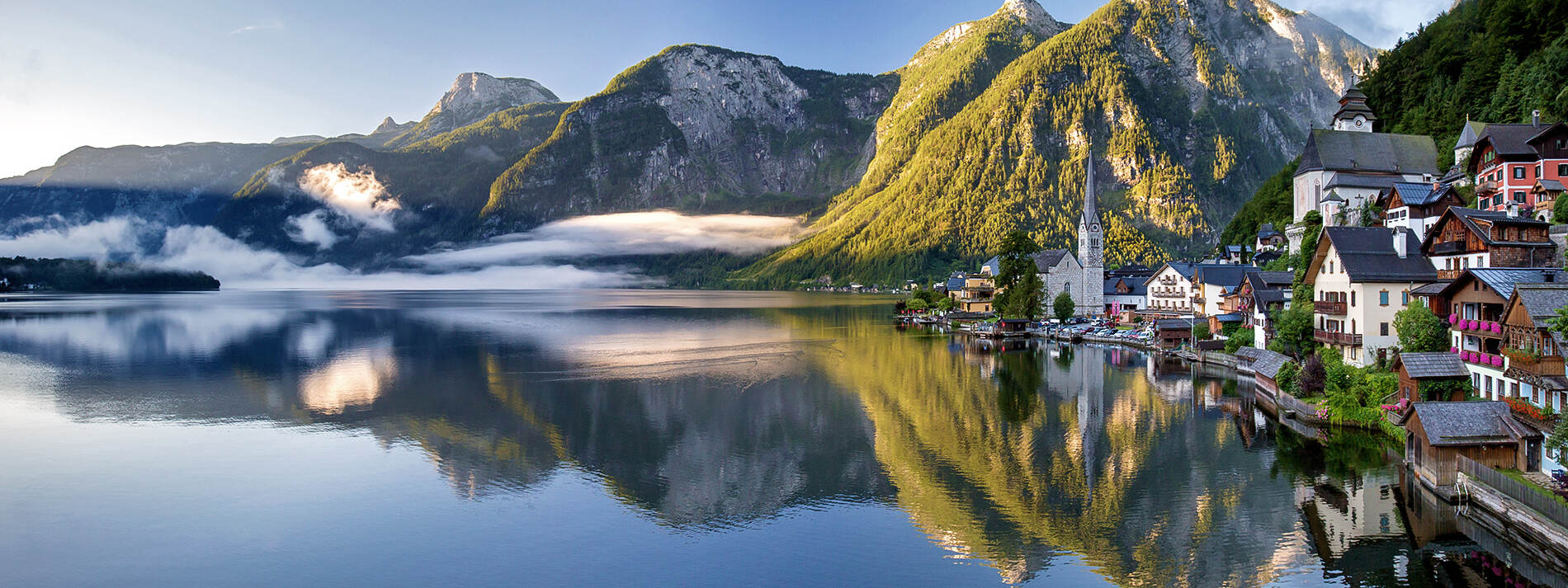 Hallstatt im Sommer mit Spiegelung im Hallstätter See, ideal für eine Tour mit Panorama Tours